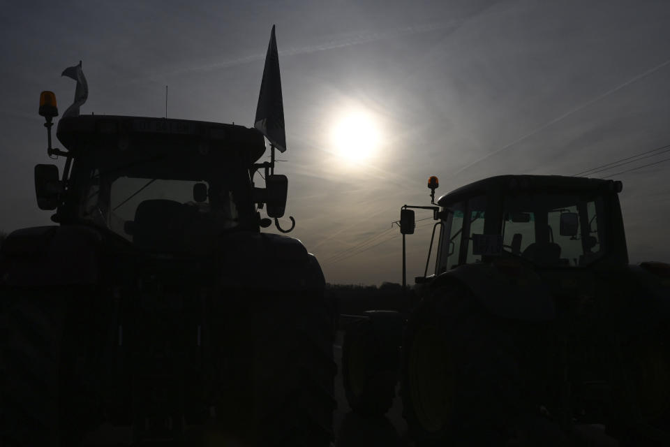 Tractors park on a highway, Monday, Jan. 29, 2024 near Roissy-en-France, north of Paris. Protesting farmers vowed to encircle Paris with tractor barricades and drive-slows on Monday, aiming to lay siege to France's seat of power in a battle with the government over the future of their industry, which has been shaken by repercussions of the Ukraine war. (AP Photo/Matthieu Mirville)