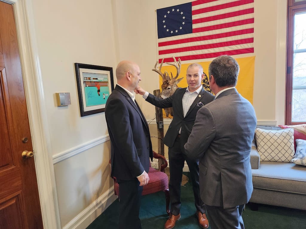 Missouri state Sens. Denny Hoskins, left, and Rick Brattin, center, confer with Freedom Caucus Director Tim Jones, right. Hoskins and Brattin are Republicans and members of the State Freedom Caucus Network, which aims to push the party further to the right. (Photo by Elaine S. Povich/Stateline)