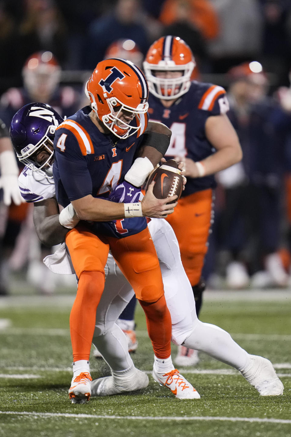 Northwestern defensive lineman Anto Saka, back left, tackles Illinois quarterback John Paddock (4) during the second half of an NCAA college football game Saturday, Nov. 25, 2023, in Champaign, Ill. (AP Photo/Erin Hooley)