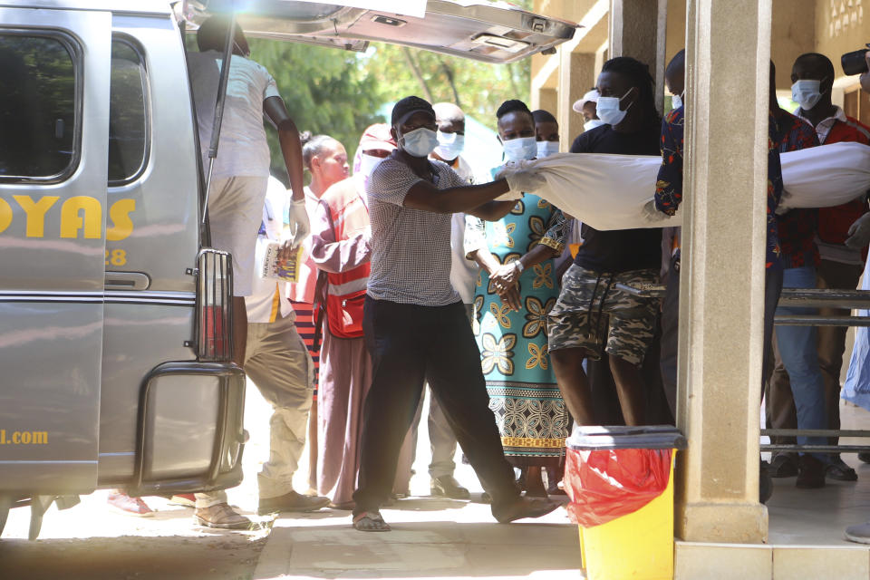 Family members carry a body of victim of a religious cult for burial in Malindi Funeral home in Kilifi, Kenya Tuesday, March. 26, 2024. Kenya government on Tuesday released seven bodies of victims, who died due to starvation to their families for burial. Some 34 bodies, out of the 429 that were exhumed last year, were positively identified. (AP Photo/Andrew Kasuku)