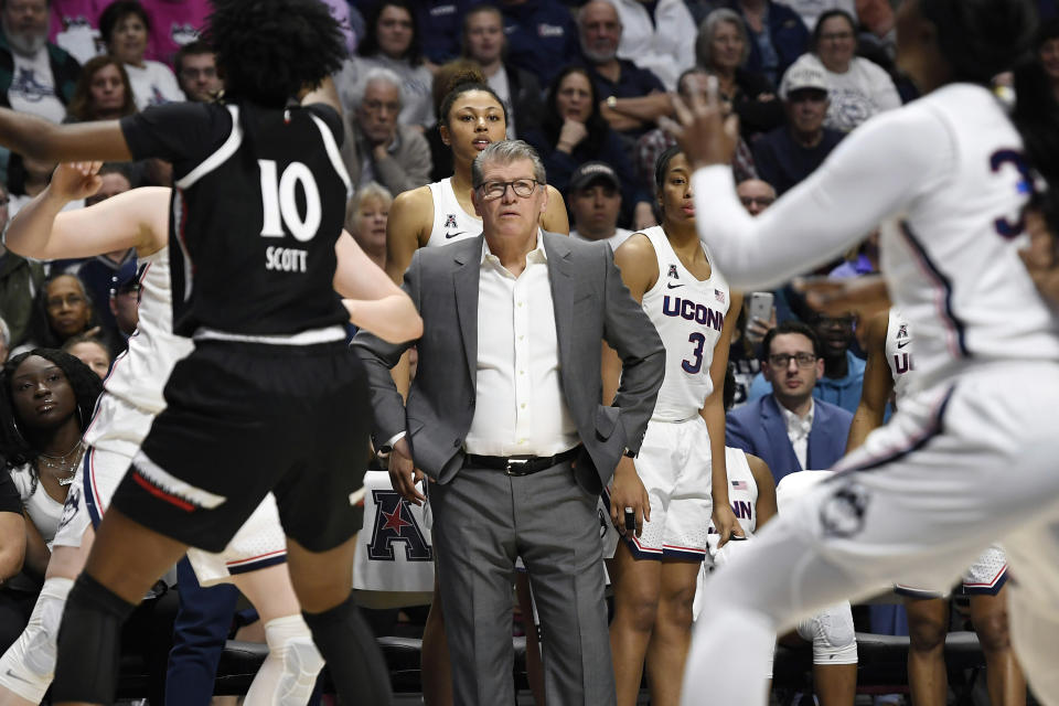 FILE- In this March 9, 2020, file photo, Connecticut head coach Geno Auriemma, center, watches play at the end of an NCAA college basketball game against Cincinnati in the American Athletic Conference tournament finals at Mohegan Sun Arena, Monday, in Uncasville, Conn. Auriemma and UConn are back home in the Big East sitting in a familiar spot — atop the preseason poll. The Huskies, who returned to the conference after seven years in the American, were the unanimous choice to win the league the Big East announced Thursday, Ocrt. 29, 2020. (AP Photo/Jessica Hill, File)