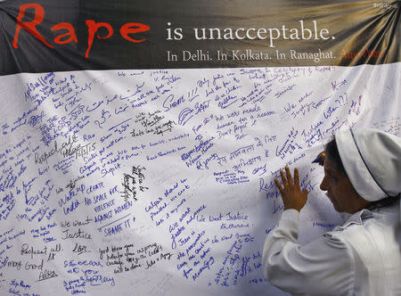 A Catholic nun from the Missionaries of Charity, the global order of nuns founded by Mother Teresa, signs a banner during a rally to show solidarity with the nun who was raped during an armed assault on a convent school, in Kolkata March 16, 2015. REUTERS/Rupak De Chowdhuri