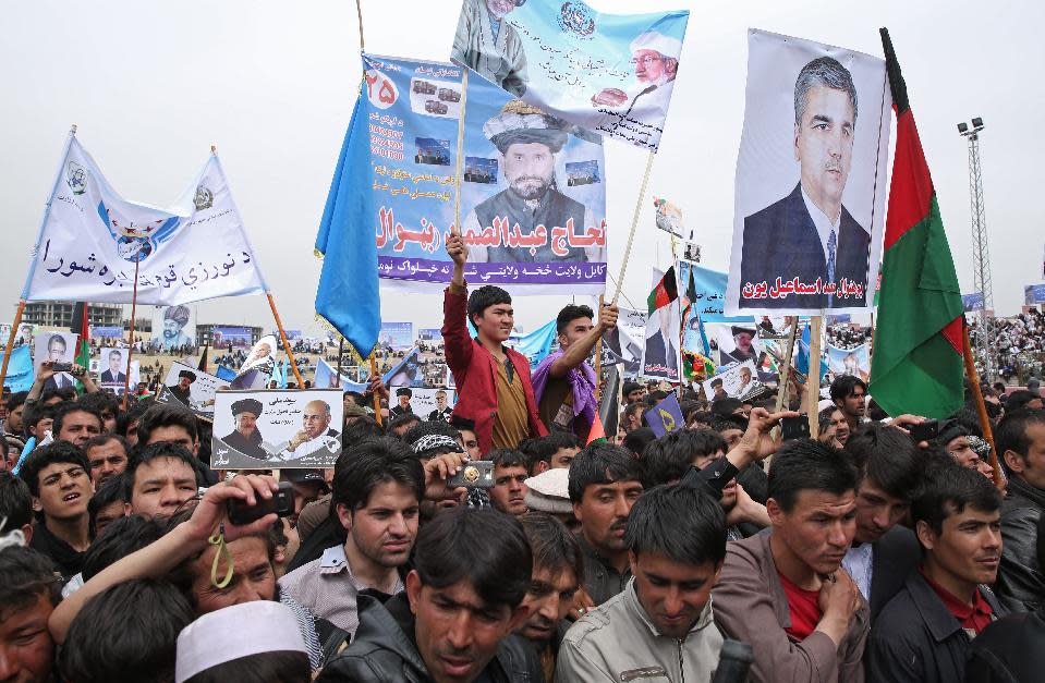 Supporters of Afghan presidential candidate Ashraf Ghani Ahmadzai listen to his speech during a campaign rally in Kabul, Afghanistan, Tuesday, April 1, 2014. Writing on the posters read, " We vote to Ashraf Ghani Ahmadzai." Eight Afghan presidential candidates are campaigning for the third presidential election. Elections will take place on April 5, 2014. (AP Photo/Massoud Hossaini)