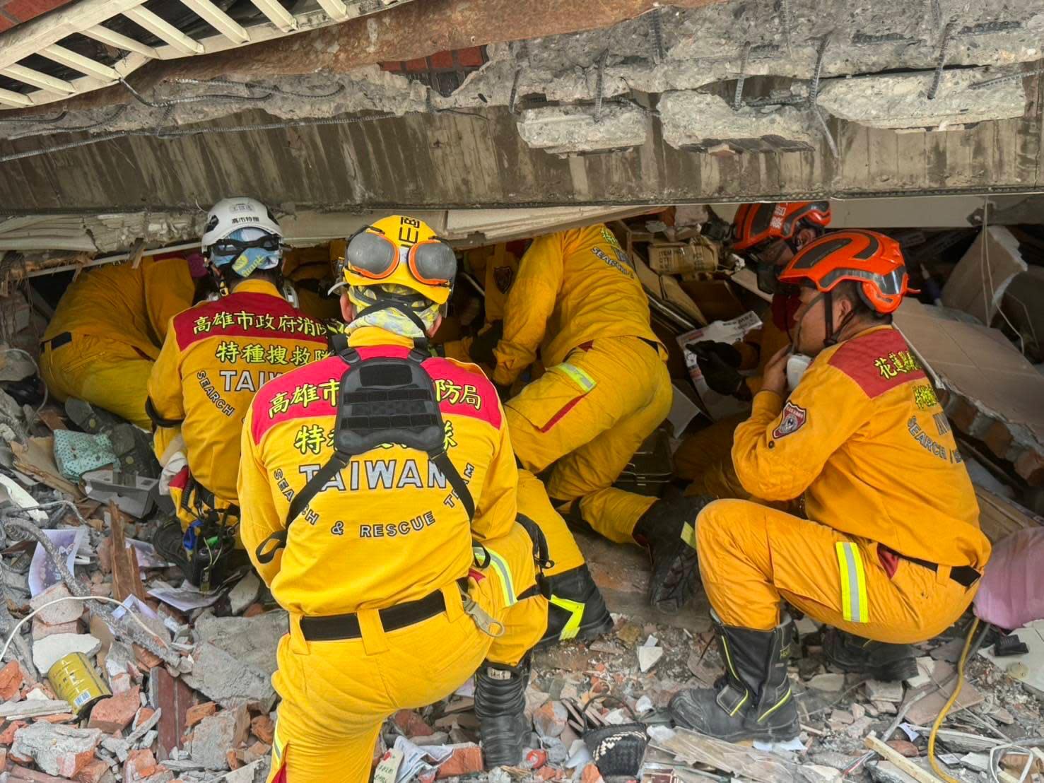 Rescue workers search for survivors under a collapsed building in Hualien City.