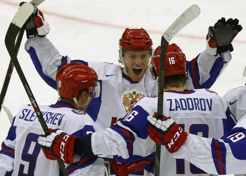 Russia's players (L-R) Anton Slepyshev, Andrei Mironov and Nikita Zadorov celebrate their goal against the U.S. in their IIHF Ice Hockey World Championship quarter-final match in Malmo, January 2, 2014. REUTERS/Alexander Demianchuk (SWEDEN - Tags: SPORT ICE HOCKEY)