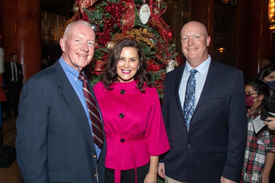 Caster Concepts President Bill Dobbins, left, and his son, Caster Concepts Vice President of Manufacturing Andrew Dobbins, smile for a photo with Gov. Gretchen Whitmer at the Michigan Service Awards Nov. 17, 2022, in Detroit.