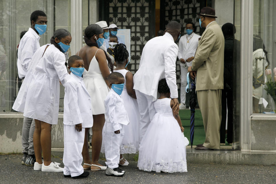 With restrictions on the amount of people who may go into the viewing at a time, eight of the grandchildren of Joanne Paylor, 62, of southwest Washington, prepare to go into the chapel in one group during her funeral at Cedar Hill Cemetery, Suitland-Silver Hill, Md., Sunday, May 3, 2020. Despite not having died from coronavirus, almost every aspect of her funeral has been impacted by the pandemic. (AP Photo/Jacquelyn Martin)