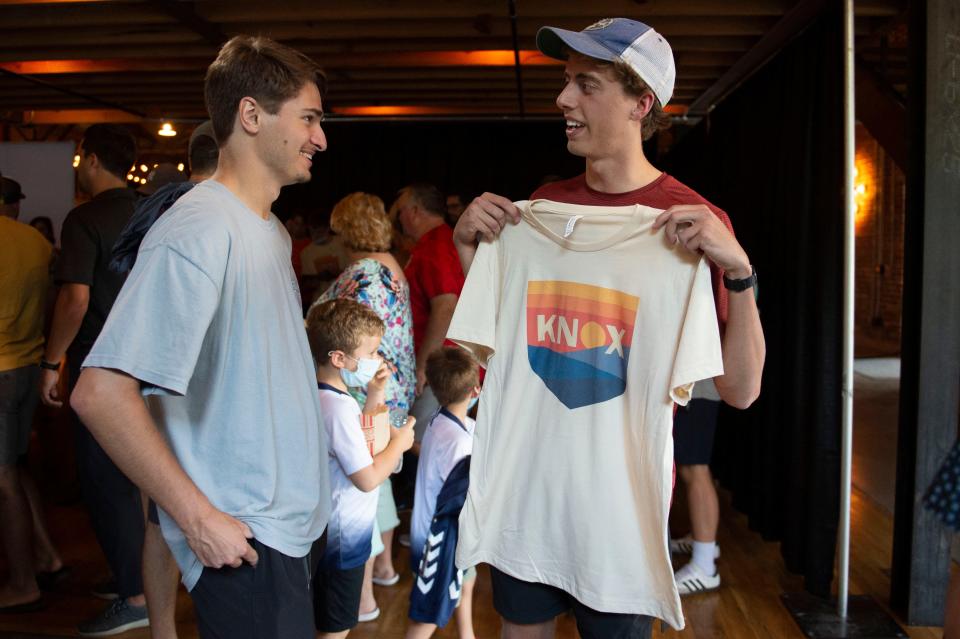 Soccer fan Robert Porter, right, shows off his new One Knoxville SC shirt to Lyndon Kennedy during a crest unveiling party at The Mill & Mine on Aug. 19. Team gear, including year one T-shirts and the recently revealed jerseys, are available at oneknoxsc.com/merch.