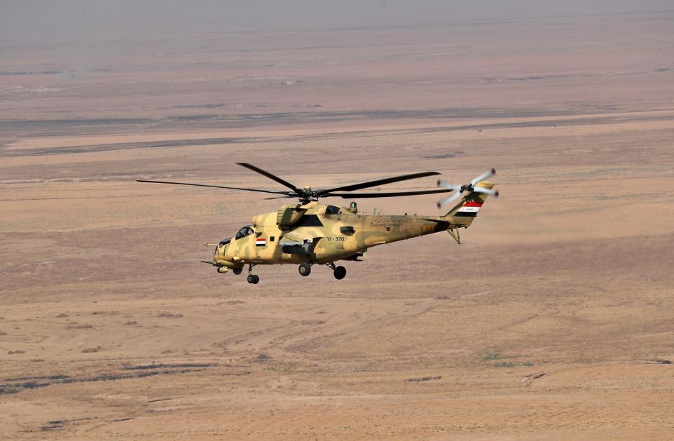 An Iraqi Air Force helicopter flies over the Rabiaa border crossing, Iraq, Wednesday, Oct. 16, 2019. Najah al-Shammari, Iraq's defense minister said that some members of the Islamic State group were able to flee northern Syria and cross into Iraq. The Iraqi official added that some of them are still at large while others were detained. (AP Photo/Hadi Mizban)