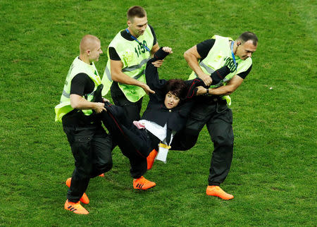 Personal de seguridad retira a un invasor del campo de juego durante la final del Mundial de Rusia, en Moscú. 15 de julio de 2015. REUTERS/Maxim Shemetov -