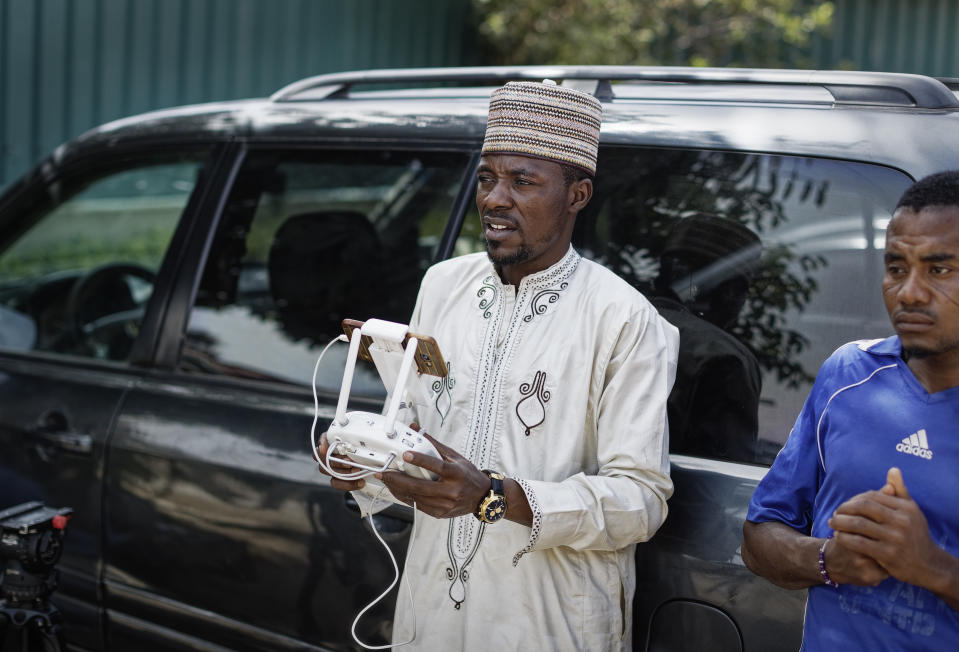 In this photo taken Monday, Feb. 18, 2019, Chairman of Kano's film association Jamilu Dakan Daka operates a drone filming a music video calling for a peaceful election, at a golf resort outside of Kano, northern Nigeria. Faced with an election that could spiral into violence, some in the popular Hausa-language film industry known as Kannywood assembled this week to shoot an urgent music video appealing to the country for peace. (AP Photo/Ben Curtis)