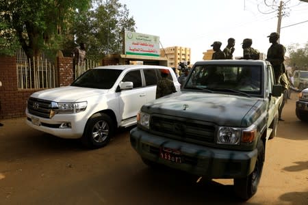 Sudanese soldiers escort the vehicle that carries Sudan's ex-president Omar al-Bashir las he leaves the office of the anti-corruption prosecutor in Khartoum