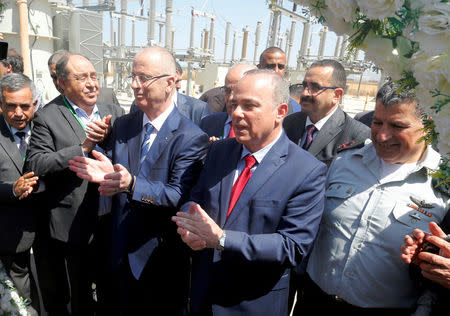 Palestinian Prime Minister Rami Hamdallah and Israeli Energy Minister Yuval Steinitz clap during the inauguration of an electrical substation near the West Bank city of Jenin July 10, 2017. REUTERS/Abed Omar Qusini