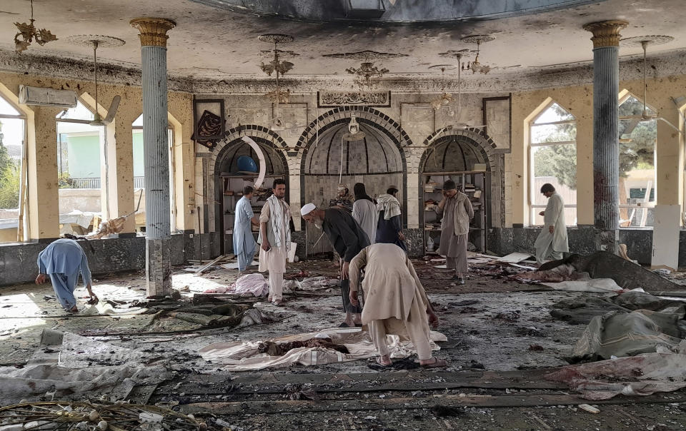 FILE - In this Oct. 8, 2021 file photo, people view the damage inside of a mosque frequented by the Shiite Muslim minority following a deadly bombing claimed by the Islamic State that killed dozens, in Kunduz province, northern Afghanistan. With the U.S. exit from the country, IS is poised to usher in another violent phase - except this time it is the Taliban playing the the role of the state. (AP Photo/Abdullah Sahil, File)