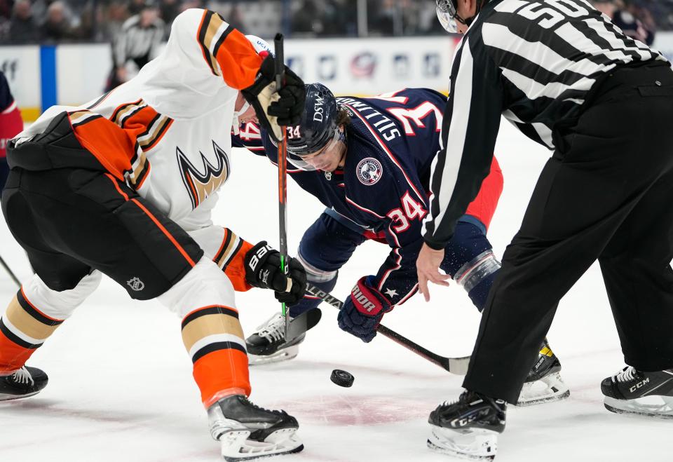 Columbus Blue Jackets center Cole Sillinger (34) takes a faceoff against Anaheim Ducks center Isac Lundestrom (21) during the first period of the NHL hockey game at Nationwide Arena in Columbus on Thursday, Dec. 9, 2021.