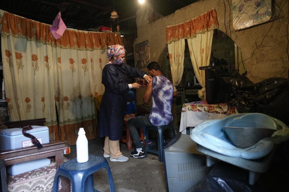 Nurse Rosaura Rodriguez inoculates a man with a dose of the Sinopharm COVID-19 vaccine during house to house vaccinations in the popular neighborhood of El Valle in Caracas, Venezuela, Monday, Sept. 27, 2021. According to the Pan American Health Organization Venezuela one of the least vaccinated countries in the continent, is seeing a growing uptick in caseloads, unlike other countries in the region where cases are dropping. (AP Photo/Ariana Cubillos)