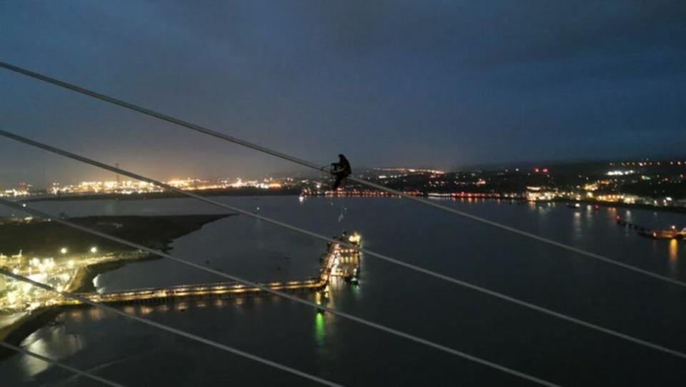 An activist climbs the bridge