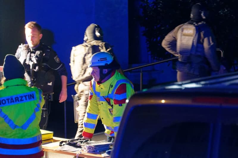 Heavily armed police officers and rescue workers are deployed outside a hospital in Aachen, where a 65-year-old woman barricaded herself inside. Henning Kaiser/dpa