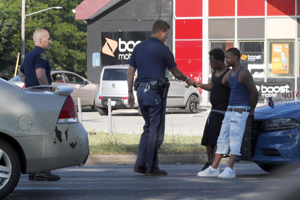 Michigan State Troopers talk with two Black men Monday, June 29, 2020, during a stop on the impoverished east side of Saginaw, Mich. Black residents have largely long been relegated to the east side of the city, where blighted and abandoned buildings line streets – remnants of the Great Recession from a decade ago. (AP Photo/Charles Rex Arbogast)