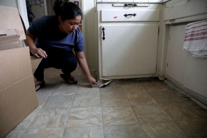LOS ANGELES, CA - APRIL 20: Martha Martinez shows where the linoleum floor in her kitchen is in need of repair at the Chesapeake Apartments on Wednesday, April 20, 2022 in Los Angeles, CA. Tenants have complained of mold, raw sewage running under the buildings, broken heaters and faulty carbon monoxide and smoke detectors. Massive habitability problems at a 425-unit apartment complex called Chesapeake Apartments in South L.A. The complex, which stretches for entire city blocks, has been on the city's radar for at least five years for having habitability and crime problems. (Gary Coronado / Los Angeles Times)