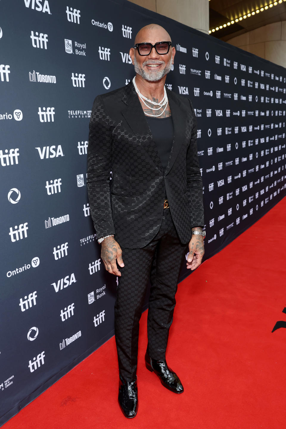 Dave Bautista attends the premiere of "The Last Showgirl" at the 2024 Toronto International Film Festival in Gucci suit, pearl necklace, diamond bracelets, men's jewelry, Jason of Beverly Hills