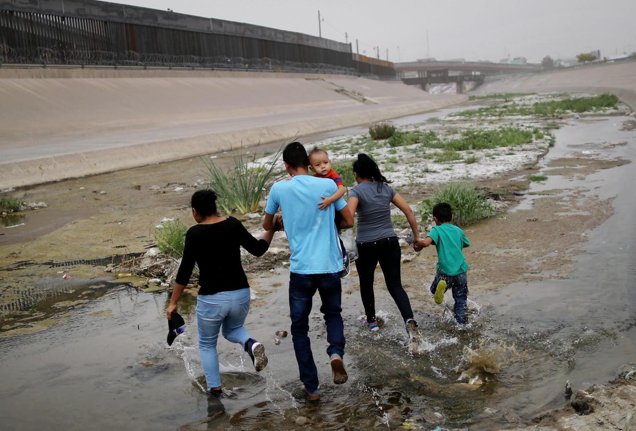 Migrants hold hands as they cross the border between the U.S. and Mexico at the Rio Grande river, on their way to enter El Paso, Texas, on May 20, 2019 as taken from Ciudad Juarez, Mexico. The location is in an area where migrants frequently turn themselves in and ask for asylum in the U.S. after crossing the border. Approximately 1,000 migrants per day are being released by authorities in the El Paso sector of the U.S.-Mexico border amidst a surge in asylum seekers arriving at the Southern border.