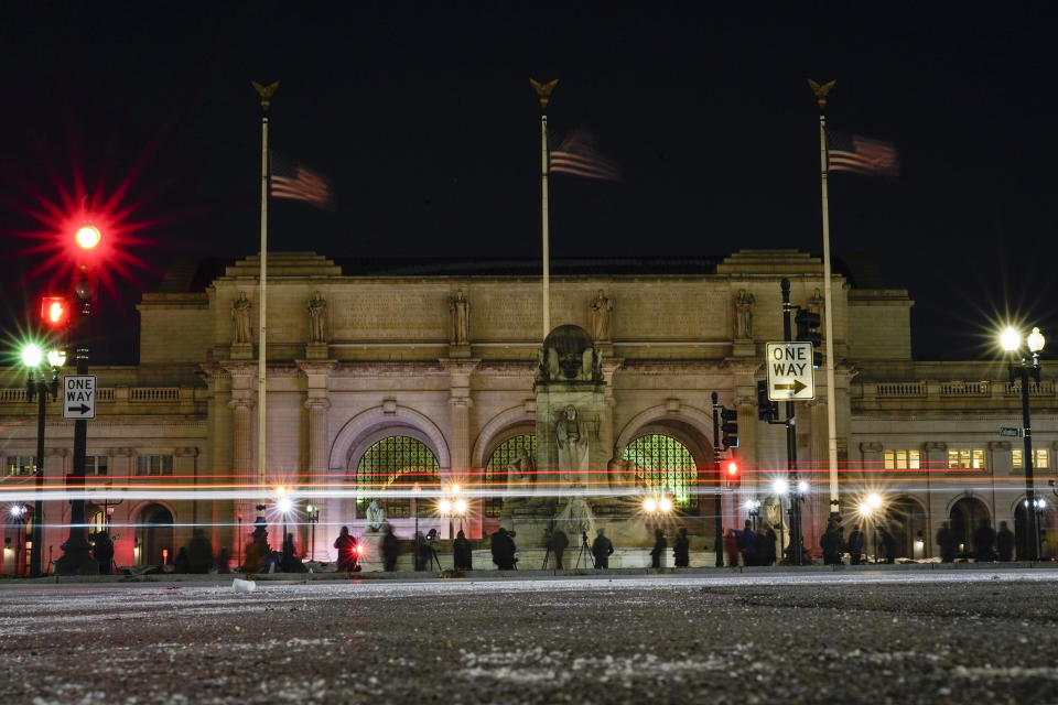 Birdwatchers line Columbus Circle in front of Union Station in Washington, Friday, Jan. 7, 2022, hoping for a glimpse of a rare snowy owl that has been seen there and around Washington's Capitol Hill neighborhood. (AP Photo/Carolyn Kaster)