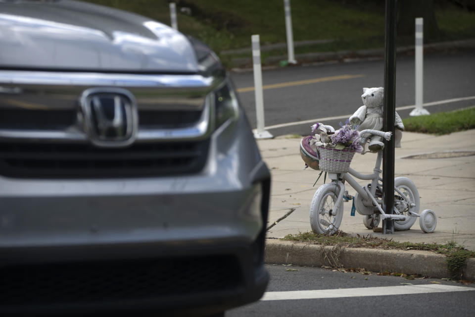 A vehicle drives past a memorial for 5-year-old Allie Hart, who was struck and killed in 2021 by a driver while riding her bicycle in a crosswalk, Monday, Sept. 11, 2023, in Washington. (AP Photo/Mark Schiefelbein)
