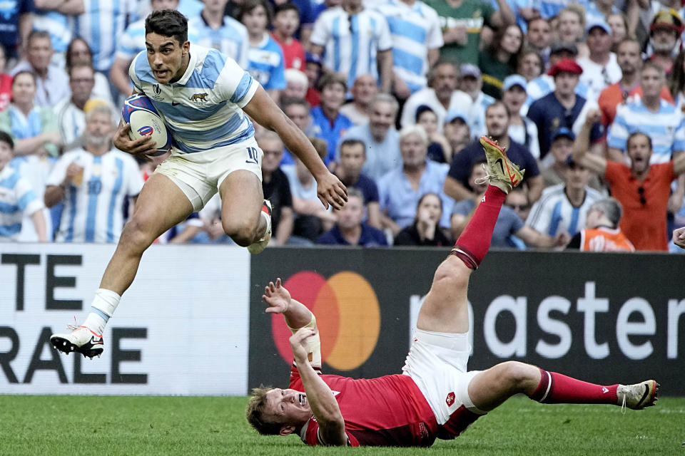 Argentina's Santiago Carreras, left, runs over Wales' Jac Morgan during the Rugby World Cup quarterfinal match between Wales and Argentina at the Stade Vélodrome, in Marseille, France, Saturday, Oct. 14, 2023. (AP Photo/Laurent Cipriani)