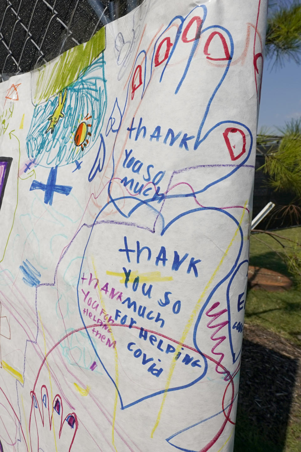 An oversized poster, drawn by the school children of an area Christian school thanking the medical workers with both Samaritan's Purse Missions and the University of Mississippi Medical Center, decorates the entrance leading to a field hospital based in a covered parking lot at the medical facility, in Jackson, Miss., Wednesday, Aug. 25, 2021. (AP Photo/Rogelio V. Solis)
