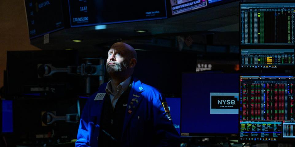 Sunlight casts across the face of a trader on the floor of the New York Stock Exchange on July 25, 2023, in New York City.