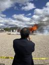 Hawaii Insurance Commissioner Gordon Ito films a wildfire burn risk demonstration at the National Interagency Fire Center in Boise, Idaho, Monday, April 29, 2024. Some property insurance companies in Hawaii and other states have stopped providing coverage to residents because of increasing wildfire risk and climbing construction costs. The Idaho Department of Insurance hosted the burn demonstration as part of a forum for western Insurance commissioners on the impact wildfires are having on the nation’s insurance market. (AP Photo/Rebecca Boone)