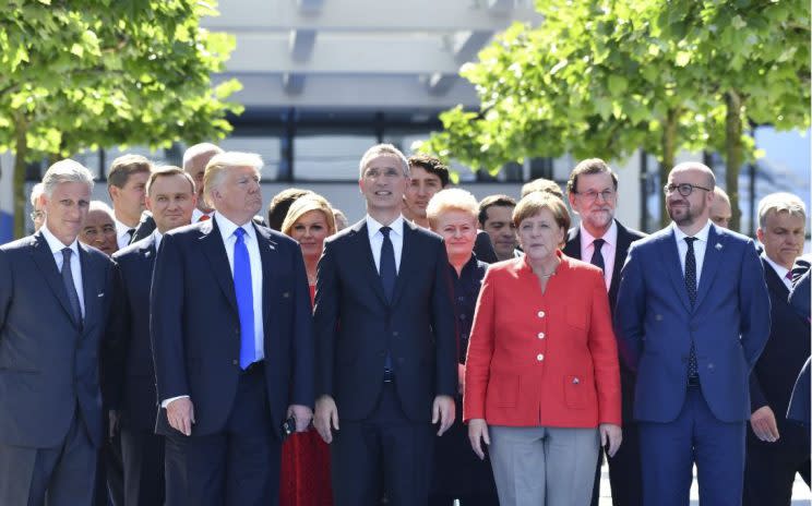 Mr Trump pictured with Angela Merkel and her fellow EU members outside the NATO summit in Brussels yesterday (Thursday) (Rex) 