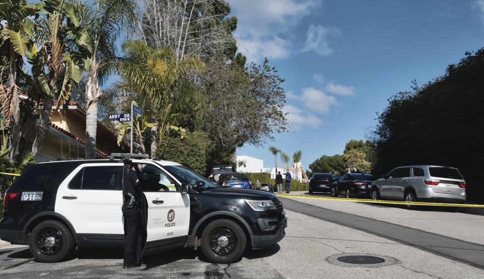 Police block a street to a house where three people were killed and four others wounded in a shooing at a short-term rental home in an upscale Los Angeles neighborhood on Saturday Jan. 28, 2023. (AP Photo/Richard Vogel)