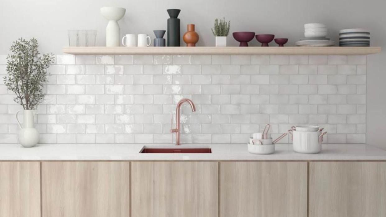  A pink kitchen with a glossy white tiled backsplash 