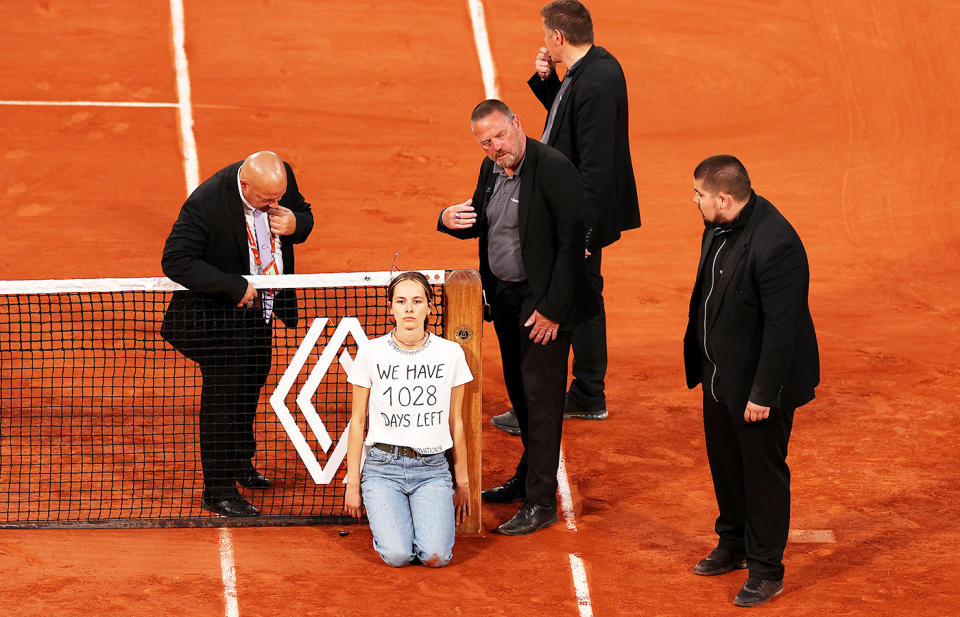 A protester, pictured here tying herself to the net during the semi-final between Marin Cilic and Casper Ruud at the French Open. 