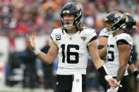 Jacksonville Jaguars quarterback Trevor Lawrence (16) tires to clarify a play call by his coaches during the first half of an NFL football game against the Tampa Bay Buccaneers Sunday, Dec. 24, 2023, in Tampa, Fla. (AP Photo/Chris O'Meara)