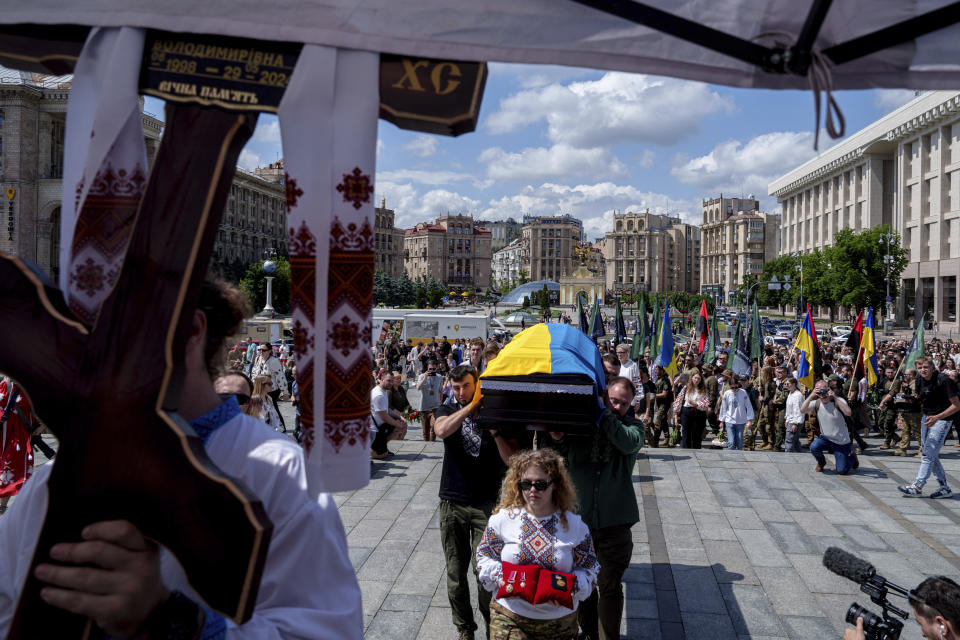Volunteers carry the coffin of the Ukrainian journalist and volunteer combat medic Iryna Tsybukh during a memorial service on Independence square in Kyiv, Ukraine, Sunday, June 2, 2024. Nearly 1,000 people attended a ceremony Sunday honoring the memory of Ukrainian journalist Iryna Tsybukh, who was killed in action while serving as a combat medic a few days before her 26th birthday. Tsybukh was killed while on rotation in Kharkiv area, where Russia started its offensive nearly a month ago. (AP Photo/Evgeniy Maloletka)