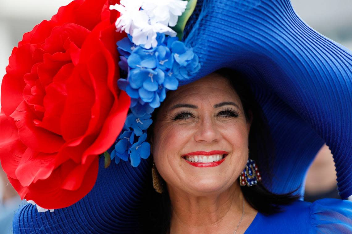 A woman in a large, bright hat featuring an oversized rose poses for a photo at Churchill Downs in Louisville, Ky., Saturday, May 6, 2023. Amy Wallot