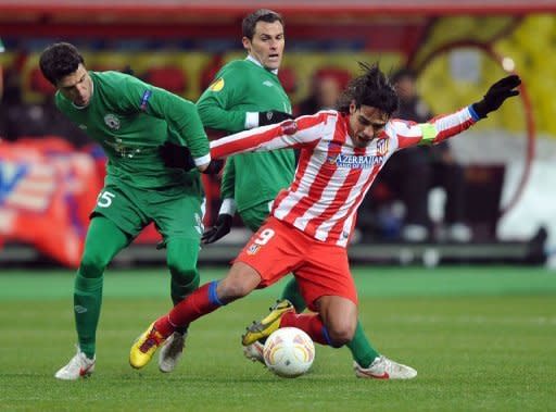 La estrella colombiana Radamel Falcao, del Atlético de Madrid, enfrenta la marca de Iván Marcano (i) y Pablo Orbaiz, del Rubin Kazan, en partido de la Europa League que el club español ganó 1-0 este 21 de febrero en Moscú, donde se despidió del torneo del que es vigente campeón dado que había perdido la ida de local 0-2. (AFP | )