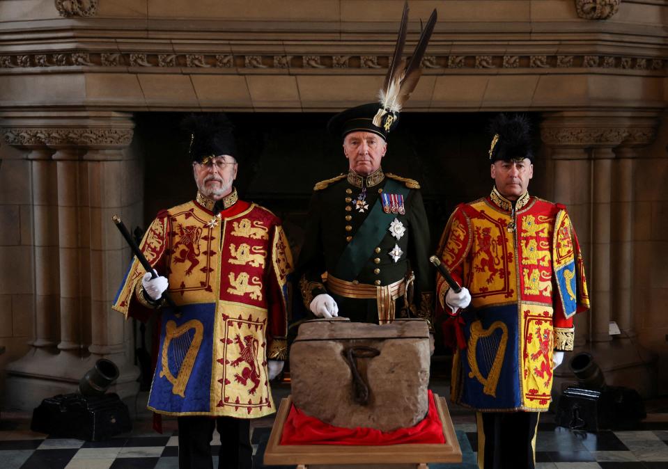 The Duke of Buccleuch Richard Scott (C), flanked by two Officers of Arms, stands by the 