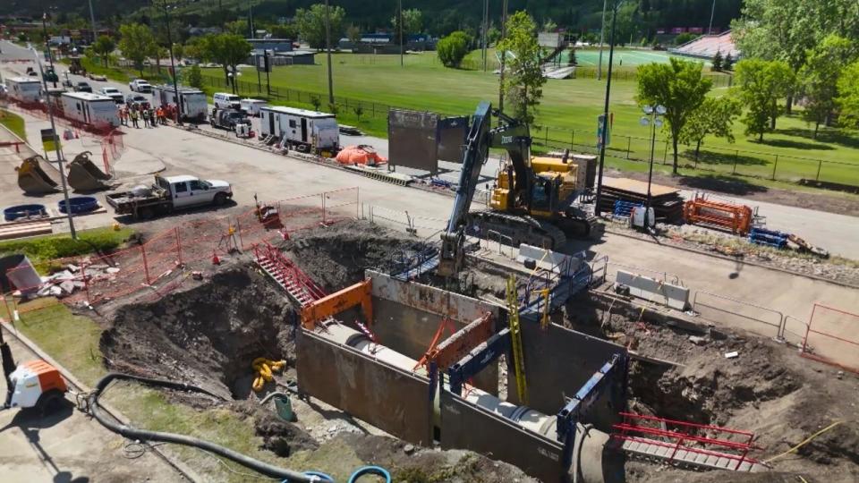 Work was paused on the site of a water main break after two people were injured.