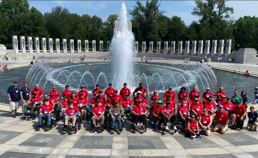 First Coast Honor Flight veterans and guardians pose in front of the World War II Memorial in Washington.