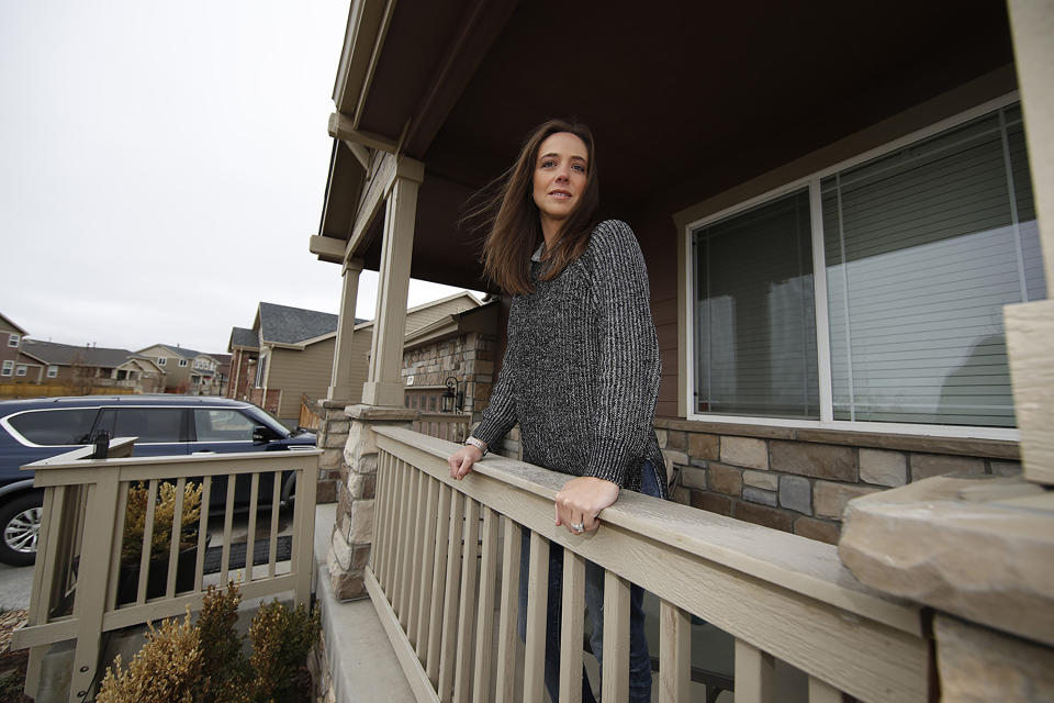 Amber Weber, a labor and delivery nurse, stands outside her home in Brighton, Colo., on Thursday, April 2, 2020. Weber, who has been cross-trained in anticipation of a surge of COVID-19 patients says, "More than one family member has told me I should quit, that it’s not worth it.” But her professional values won out. (AP Photo/David Zalubowski)