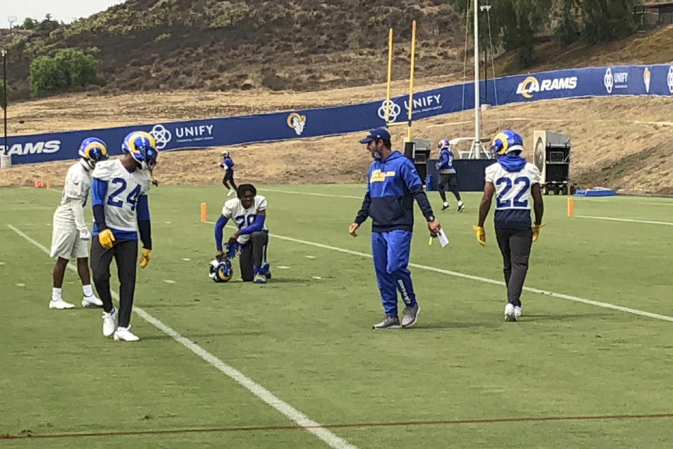 Los Angeles Rams defensive coordinator Brandon Staley, second from right, instructs safety Taylor Rapp (24), cornerback Jalen Ramsey (kneeling) and cornerback Troy Hill (22) during football practice at the team's training complex in Thousand Oaks, California, Friday, Sept. 11, 2020. Staley is in his first season as an NFL coordinator after a meteoric rise in his profession since 2016, when he was the defensive coordinator at Division III John Carroll University. (AP Photo/Greg Beacham)