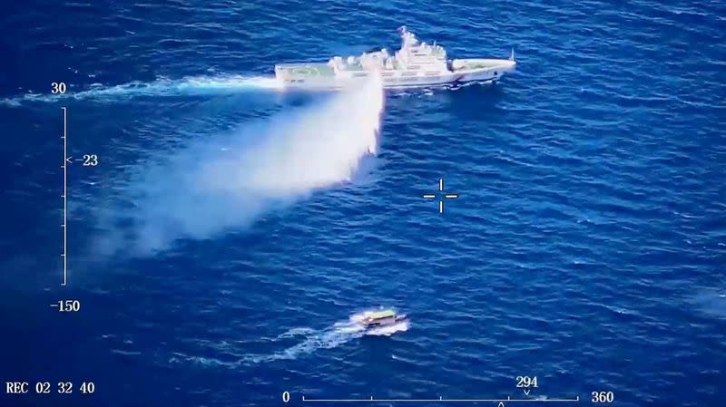 A Chinese Coast Guard ship launches what the Coast Guard says is a warning water cannon spray in the direction of a Philippine vessel at an unknown location at sea