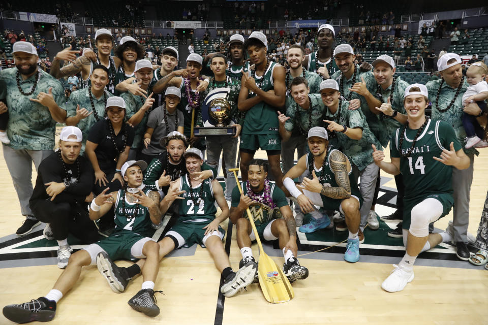 Hawaii hoists the winning trophy after defeating SMU to win the Diamond Head Classic NCAA college basketball game, Sunday Dec. 25, 2022, in Honolulu. Hawaii defeated SMU 58-57. (AP Photo/Marco Garcia)