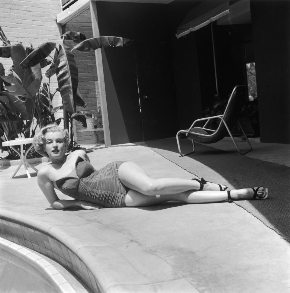 In a strapless bathing suit and high heels, circa 1951.