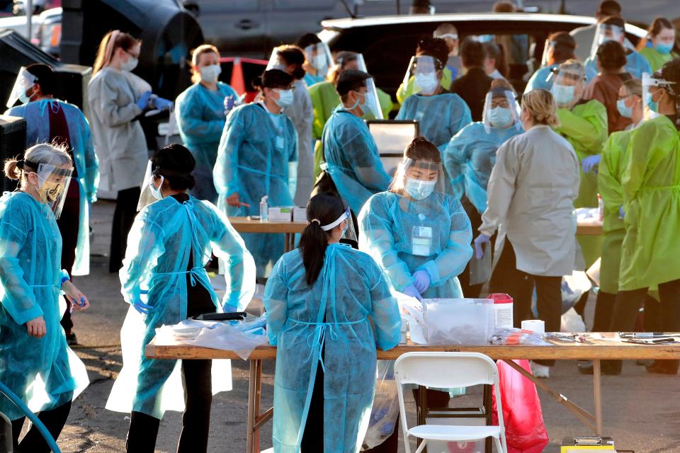 Medical personnel prepare to test hundreds of people lined up in vehicles Saturday, June 27, 2020, in Phoenix's western neighborhood of Maryvalefor free COVID-19 tests organized by Equality Health Foundation, which focuses on care in underserved communities.