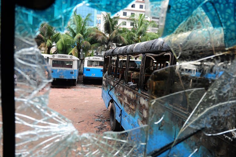 Burnt-out government vehicles are parked following a clash between police and Islamists in Dhaka on May 6, 2013